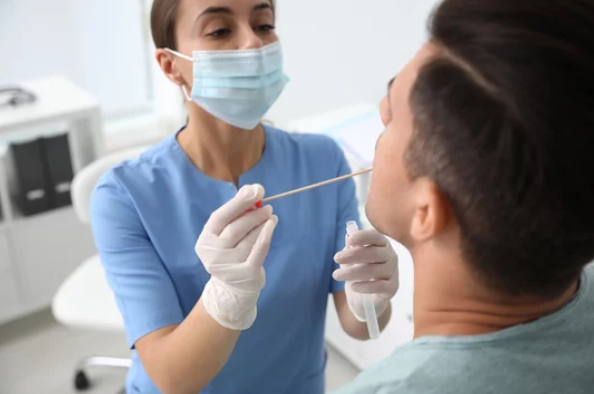 Healthcare professional performing saliva antidoping drug test for marijuana, cocaine, amphetamines, methamphetamines, barbiturates, and opiates detection