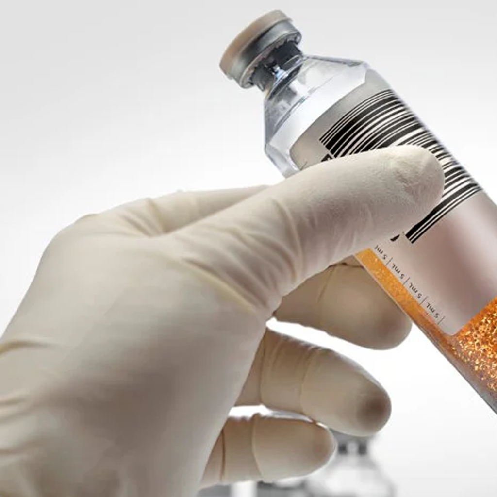 Gloved hand holding a blood sample vial for HEMOCULTIVO ANAEROBIO laboratory test detecting bacteria and microbes.