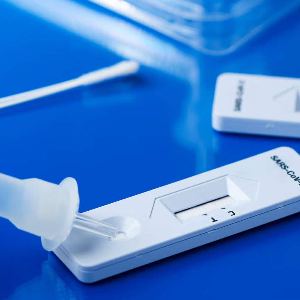 Rapid influenza type A and B diagnostic test kit with sample dropper and swab on blue background