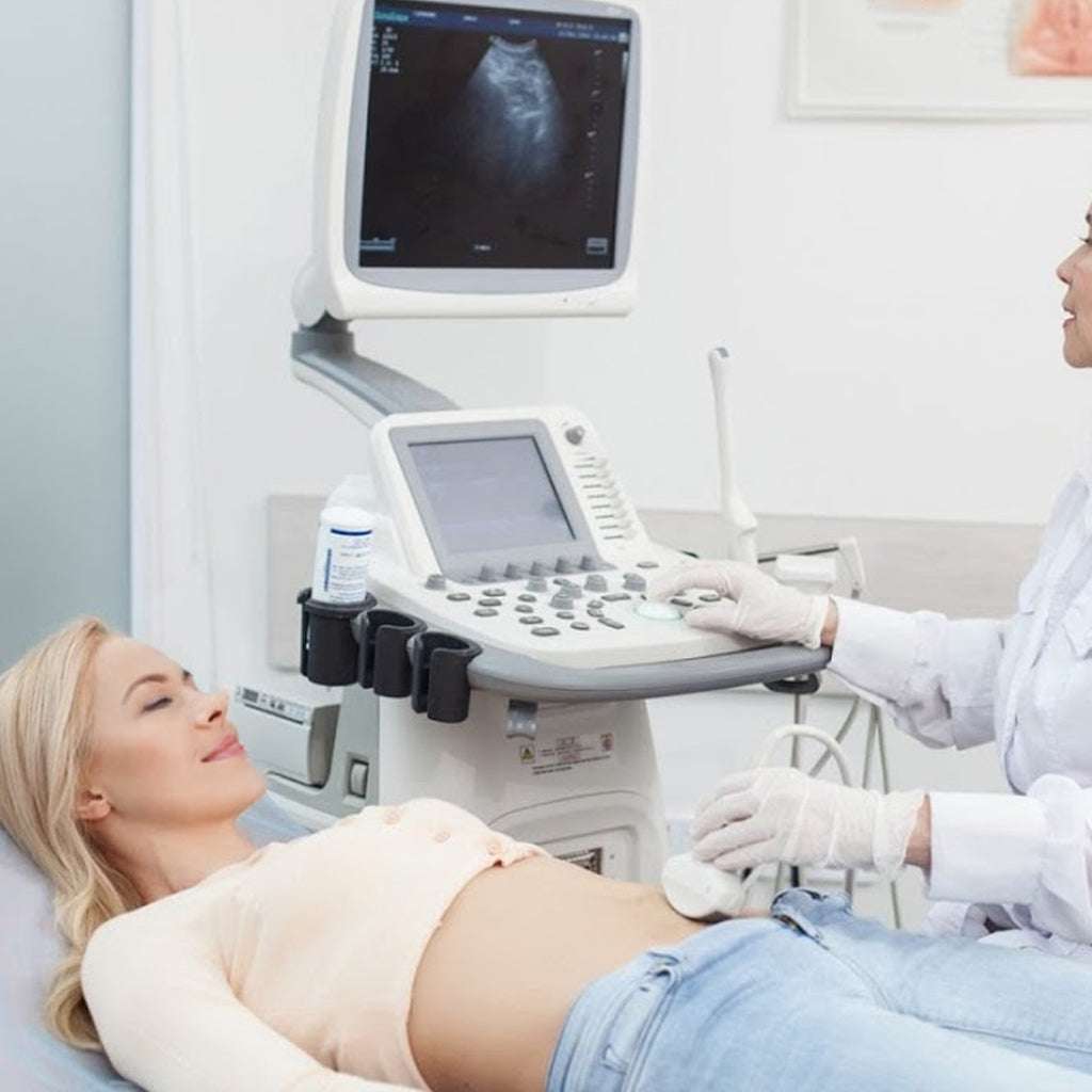 woman undergoing ULTRASONIDO GINECOLOGICO PELVICO with medical professional using ultrasound machine