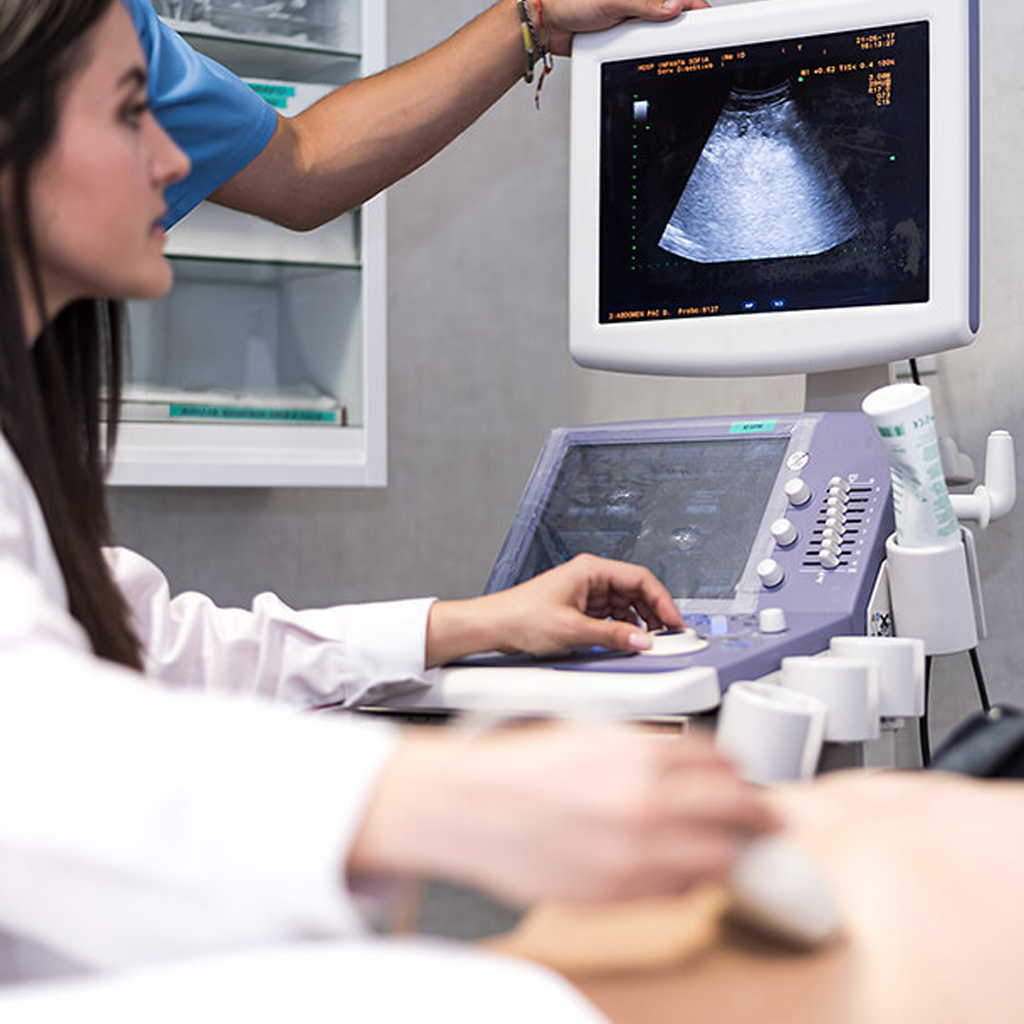 medical professional performing ultrasonido abdomen completo ultrasound scan showing internal abdominal organs on monitor